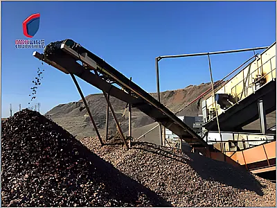 Mobile impact crushing station with conveyor discharging material onto a stockpile at a quarry site