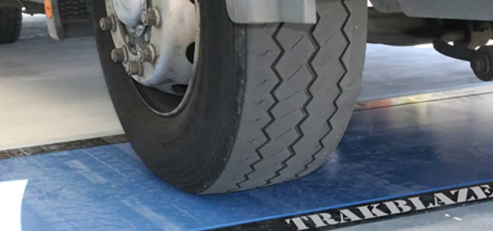 Ban truk melintas di atas weigh pad berprofil rendah yang rata dengan permukaan jalan